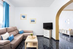 een woonkamer met een bank en een tv bij Apartamento Horizonte Azul in Punta del Hidalgo