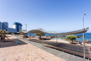 Ein Park mit Bänken und einem Spielplatz direkt am Meer in der Unterkunft Apartamento Vistas Al Mar y al Teide in Puerto de la Madera