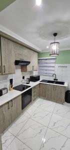a large kitchen with wooden cabinets and a sink at Mountain-Ridge Lux Stay in Rustenburg