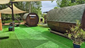 een tuin met een hobbithuisje en gras bij Mini Hotel Übernachten Im Gurkenfass in Lübbenau