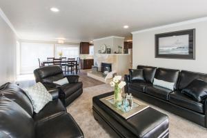 a living room with black leather furniture and a kitchen at Beach Drive Suites in Seaside