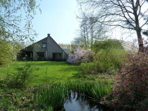 a house with a pond in front of it at BnB Heimdall in Brecht