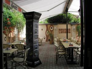 an outdoor patio with tables and chairs and an umbrella at Roxane Panzio in Budapest