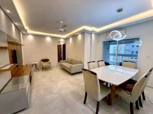 une salle à manger et un salon avec une table et des chaises dans l'établissement Apartmento com 3 dorm no Canto do Forte, à Praia Grande