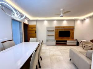 un salon avec une table et une télévision dans l'établissement Apartmento com 3 dorm no Canto do Forte, à Praia Grande 14 autres photos