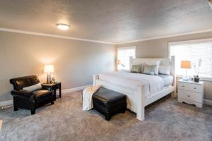 a bedroom with a white bed and a chair at Beach Drive Suites in Seaside