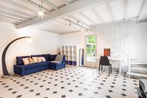 een woonkamer met een blauwe bank en een tafel bij L'escapade d'Etretat in La Celle-sous-Gouzon