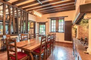 een grote eetkamer met een houten tafel en stoelen bij L'escapade d'Etretat in La Celle-sous-Gouzon