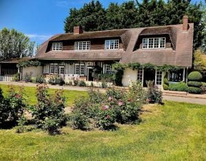 een groot huis met bloemen in de tuin bij L'escapade d'Etretat in La Celle-sous-Gouzon