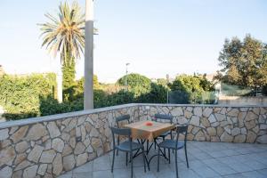 a patio with a table and chairs on a stone wall at La Casetta di Josh in Marsala