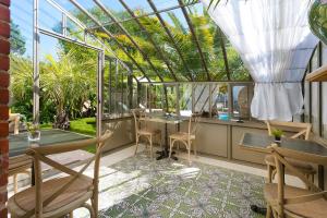 a conservatory with tables and chairs on a patio at Villa la Ruche in La Baule