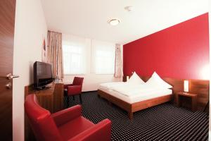 a hotel room with a bed and a red wall at Hotel Greive in Haren