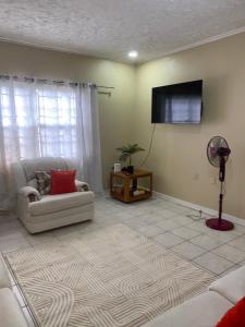 a living room with a couch and a flat screen tv at Royal View Villa in Bull Savanna