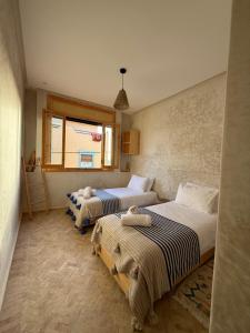 En eller flere senge i et værelse på Numidia Surf House