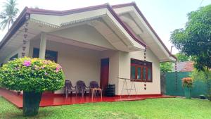 a small house with chairs in the yard at Mutu villa in Dickwella