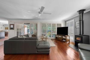 een woonkamer met een bank en een flatscreen-tv bij Bliss at Jervis Bay - pet-friendly Vincentia home in Vincentia