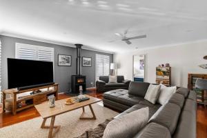 een woonkamer met een bank en een flatscreen-tv bij Bliss at Jervis Bay - pet-friendly Vincentia home in Vincentia