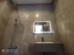 a bathroom with a sink and a mirror at Nest Homestay in Cat Tien