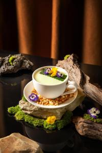 uma chávena de café sentada num prato numa mesa em Hong Ngoc Dynastie Boutique Hotel & Spa em Hanói