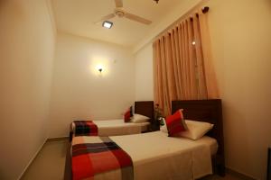 um quarto de hotel com duas camas e uma janela em Orchidee Apartments em Mount Lavinia