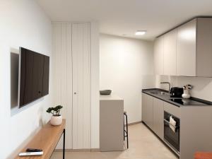a kitchen with white cabinets and a counter top at Studio in central Crans-Montana in Crans-Montana