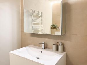 a bathroom with a white sink and a mirror at Studio in central Crans-Montana in Crans-Montana +2 photos