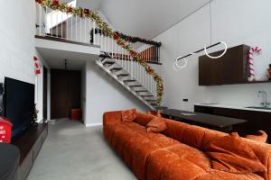 een bruine bank in een woonkamer met een trap bij Нова Дача  +6 foto's