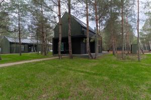 a house in the middle of a field with trees at Нова Дача in Kozintsy