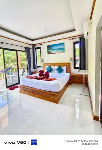 ein Schlafzimmer mit einem großen Bett und einigen Fenstern in der Unterkunft Lanta Buddy Resort in Ko Lanta