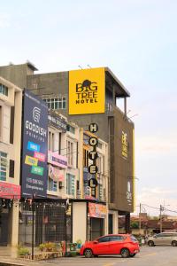 a red car is parked in front of a building at BIG TREE HOTEL in Temerloh