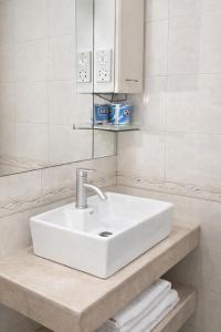 a white sink in a white bathroom with towels at Rainbow Hotel in Dar es Salaam