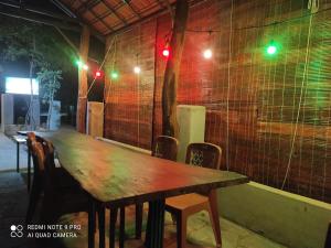 a wooden table with chairs in a room with lights at Nest Homestay in Cat Tien