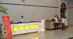 a group of people standing around a counter in a kitchen at Sheng Lin Na Hotel Minzhi Branch in Shenzhen