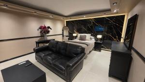 a bedroom with a bed and a leather couch at Luxury Suites Seoul Consulado in Zaragoza