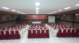 a large room with red and white chairs in it at Athaya Hotel Kendari in Pipulu