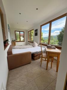 een slaapkamer met een bed, een tafel en ramen bij Villa Hansalhof, Wohnung Rosenduft in Mariapfarr