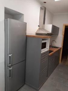 een keuken met een roestvrijstalen koelkast en een magnetron bij Grattacielo Rooms in Turijn +22 foto's