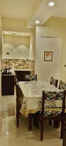 een eetkamer met een tafel en stoelen en een keuken bij ASHOK VILLA in Jaipur
