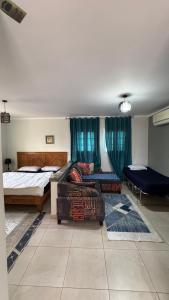 Blue Hole Hotel في دهب: غرفة نوم بها سريرين وأريكة بداخلها +135 صورة