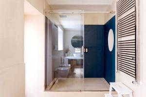 a bathroom with a toilet and a blue wall at Palazzo Castrone, Luxury Apartment in Palermo +45 photos