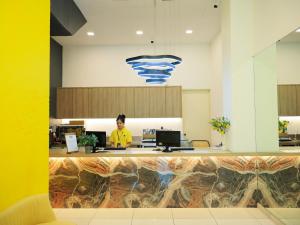 a person sitting at a desk in an office at BIG TREE HOTEL in Temerloh