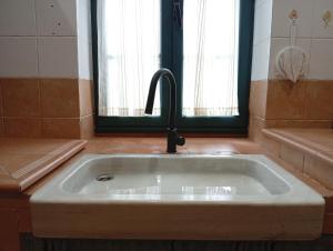 a sink with a faucet in a bathroom at A Casa da Rianxeira in A Pobra do Caramiñal +36 photos