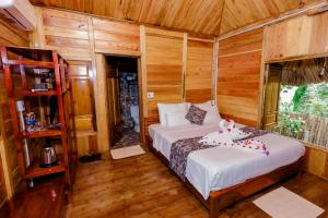 a bedroom with two beds in a room with wooden walls at La Maison De Buoc in Mai Chau