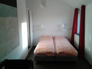 un piccolo letto in una stanza con una finestra di Les Secrets du Chat a Clavier