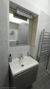 ein Badezimmer mit Waschbecken und Spiegel in der Unterkunft La Casa del Ferroviere in Letojanni