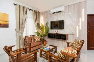 a living room with two chairs and a tv at The Islands Breeze Villa in Dehiwala +37 photos