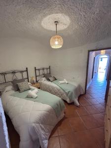 a bedroom with two beds and a chandelier at Bike Cueva - Badlands in Gorafe