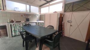 a kitchen with a table and chairs in a room at Casa del Ferroviere in Letojanni