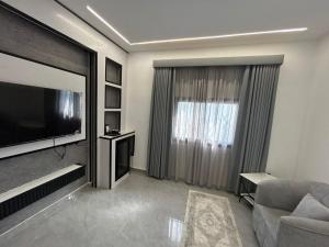 un soggiorno con grande TV e divano di قمرة قباء Quba moon1 a Medina