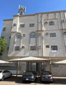 due auto parcheggiate davanti a un edificio di قمرة قباء Quba moon1 a Medina